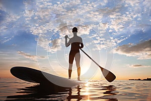 Stand-up paddle, paddle standing, silhouette of man on the beach