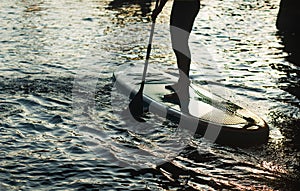 Stand up paddle surfing silhouette. a man stands with a paddle on a Board closeup,