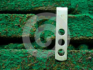 Stand wall clamp affixed on brick green wall photo