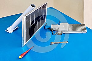 Standalone LED Solar Street Light in form of spare parts is laid out on assembly table.