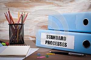 Standard Processes, Office Binder on Wooden Desk. On the table c photo