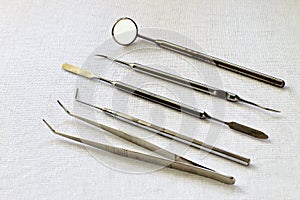 Standard set of medical dental instruments on white gauze background. Retro. Black and white photo.