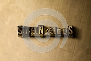 STANDARDS - close-up of grungy vintage typeset word on metal backdrop