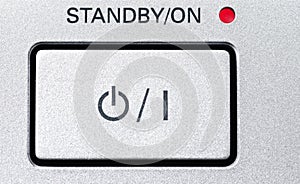 Standby-button in a gray with a grainy texture.