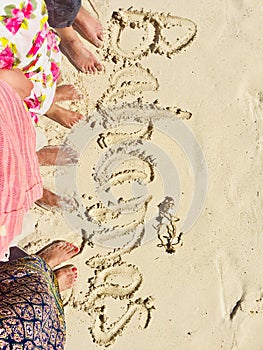Standing on beach  sand  barefoot  writing on sand  Bahamas
