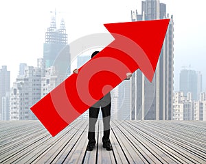 Standing businessman holding red arrow sign