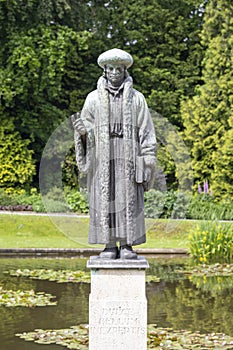 Erasmus sculpture against a green tree background photo