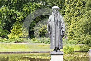 Erasmus sculpture against a green tree background photo