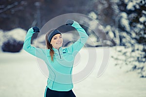 Standing girl wearing winter sportswear, trees background