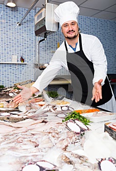 Standing laughing man shows the fish counter photo