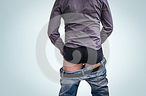 Standing man has undress jeans and peeing