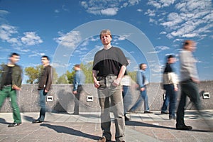 Standing man among moving pedestrians