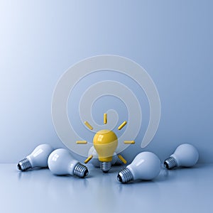 Standing out from the crowd concept bright yellow idea bulb with the dim unlit white bulbs on light blue background