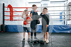 Standing and posing for a camera. Boys training boxing in the gym together
