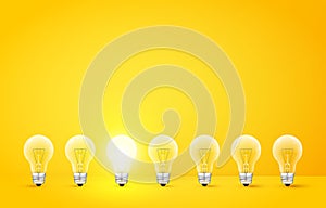 Standing in a row light bulbs with glowing one on yellow background. Unlike others or odd man out concept. Vector photo