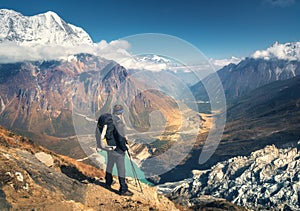 Standing sporty man with backpack on the mountain peak