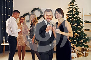 Standing together. Group of people have a new year pary indoors together photo