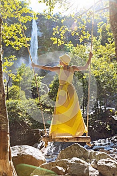 Standing woman dangles on a swing photo