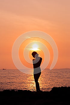 Standing woman silhouette on sea background