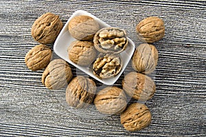 Standing on the wooden plate on a white background dry walnut,