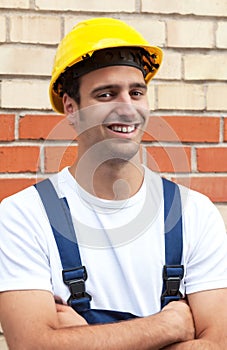 Standing worker in front of a brick wall