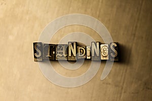 STANDINGS - close-up of grungy vintage typeset word on metal backdrop photo