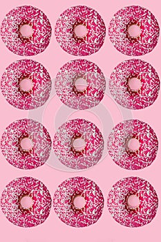 Standout donut. 12 pink donuts. flat lay. pink background photo