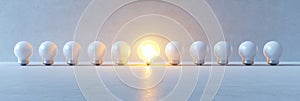 Standout innovation concept with glowing light bulb amidst lineup for creative design. Symbolism of fresh starts photo