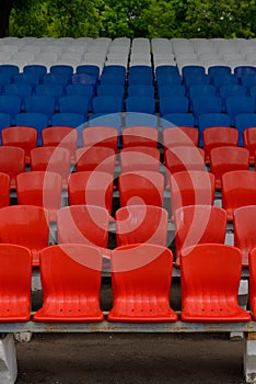stands of a small stadium with rows of white, blue and red seats