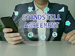 STANDSTILL AGREEMENT phrase on the screen. Broker use cell technologies at office