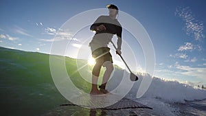 Standup paddle board surfing waves early morning beach