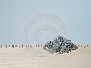 Staple gun malfunctions creating precise row and random pile of staples photo