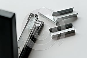 Stapler black with paper clips isolated on white background