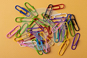 Staples paper clip of different colours on yellow