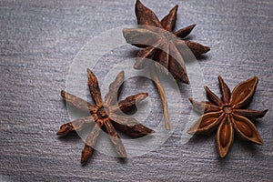 Star anise (badian) seeds and whole star-shaped pericarps in macro details.