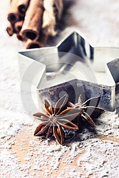 Star anise cookie cutter cinnamon and flour on baking board. Christmas baking utensil and holiday concept