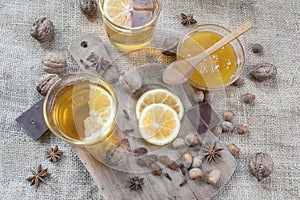 Star anise, orange frut sliced, cinnamon, jar of honey, nuts and cloves on wooden table. photo