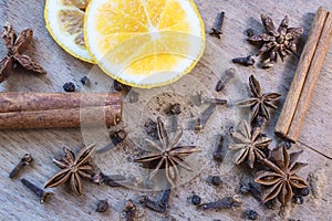 Star anise, orange frut slices, cinnamon and cloves on wooden table. photo