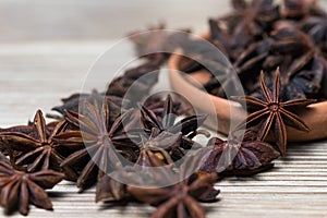 Star anise with and without seed, closed, in a clay plate on a light wooden surface. spice for the recipe. background photo