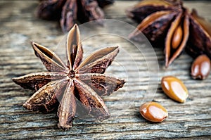 Star anise and seeds on wooden background