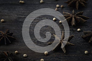 star anise spices and white pepper seed on dark wooden table texture