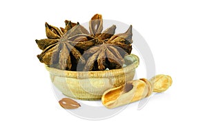 Star anise in a wooden cup with a spoon for spices isolated on a white background. Collection of spices and herbs