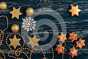 Star cookies, Christmas balls and a snowflake on an old wooden background.