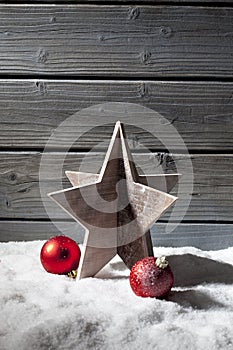 Star decoration red christmas spheres on pile of snow against wooden wall