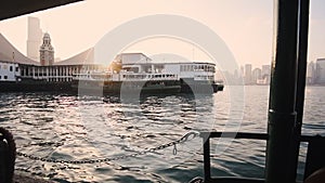 Star Ferry Pier At Tsim Sha Tsui With Clock Tower And Bright Sunset On The Background In Hong Kong.