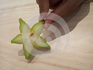 Star fruit closeup holds by fingers