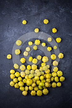Star gooseberry, small star shaped yellow berries fruit scattered on black