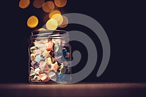Star origami in glass jar with a festival light , symbol for gif