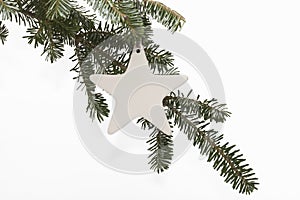 Star ornament on Christmas tree branch