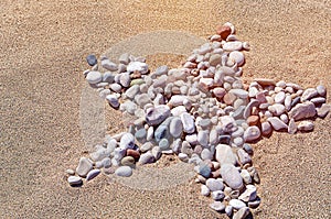Star shape created with sea pebbles on a sand